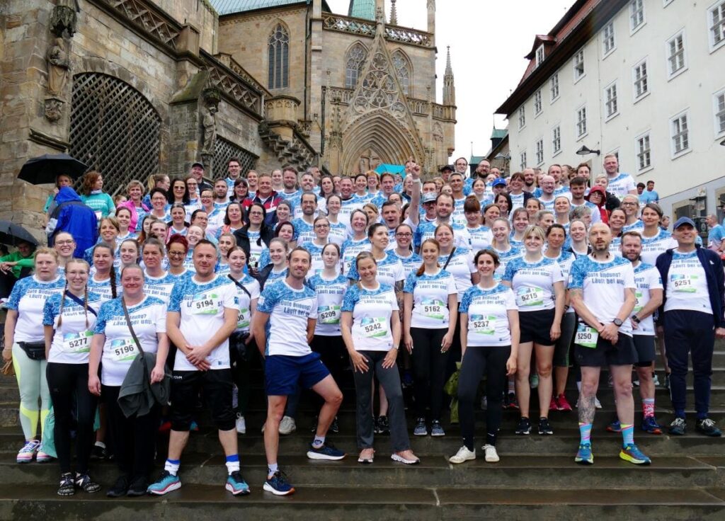 Teamfoto auf den Domstufen vor Beginn des RUN Unternehmenslaufs